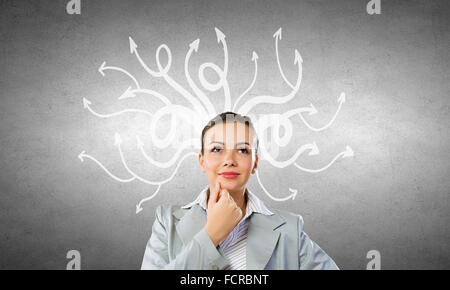 Young pensive businesswoman and thoughts coming out of her head Stock Photo