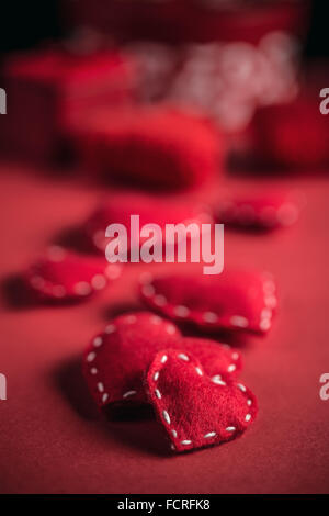 Red felt hearts on red background Stock Photo
