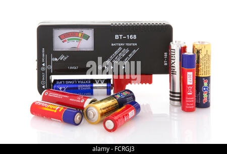 Battery Tester with assortment of dry cells for testing on a white background Stock Photo