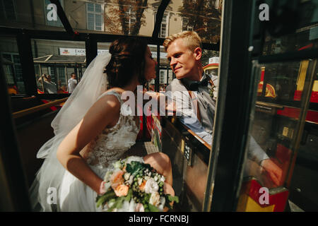 Bride and groom posing in a tour car