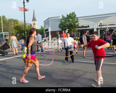 Kids and adults trying out hula hoops at an art event in North Adams, Massachusetts. Stock Photo