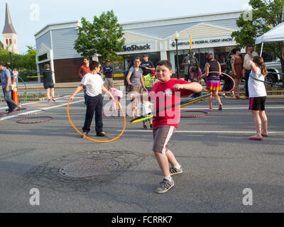 Kids and adults trying out hula hoops at an art event in North Adams, Massachusetts. Stock Photo