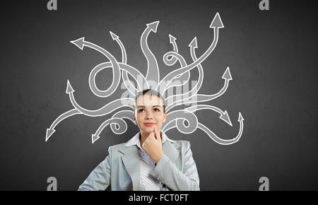 Thoughtful businesswoman with arrows and thoughts coming out of her head Stock Photo