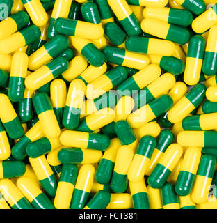 Filled frame of medicine capsules in green and yellow colors. Stock Photo