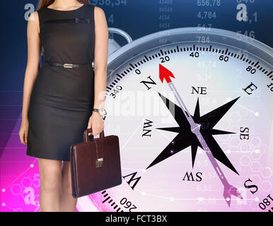 Girl holding leather briefcase in his hand standing on background of compass Stock Photo