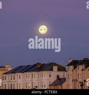 25/01/2016 at Worthing Pier, Worthing. The moon sets over the Georgian terraces on worthing seafront in a deep red/pink sky. Picture by Julie Edwards/Alamy Live News Stock Photo