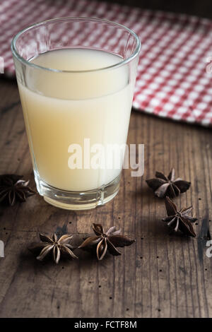 Glass with french Pastis on wooden Table Stock Photo
