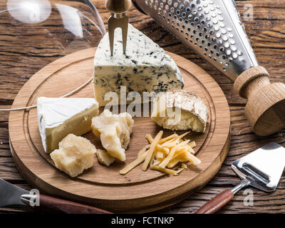 Variety of cheeses on a wooden board. Stock Photo