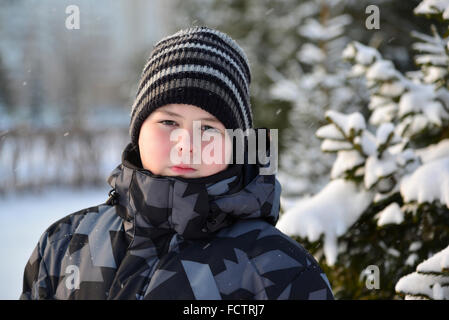 Portrait of serious teenage boy at a pine forest in winter Stock Photo