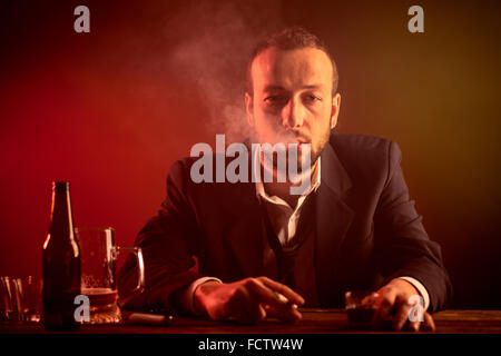 Drunk Businessman Smoking a Cigarette in a Bar Stock Photo