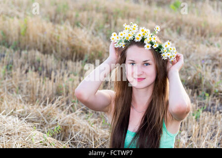 girl with  wreath of daisies in a  field Stock Photo