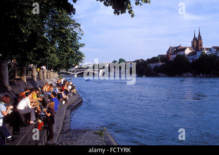 CHE, Switzerland, Basel, young people at the banks of the river Rhine in the district Kleinbasel, view to the old part of the to Stock Photo
