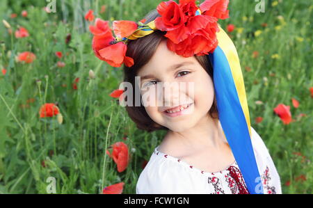 Smiling Girl on Poppy Meadow in Wreath with Ukrainian Flag Colors Ribbons Stock Photo