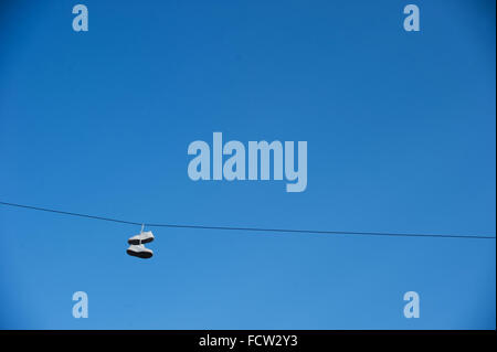 Training shoes hanging on telephone wire Stock Photo