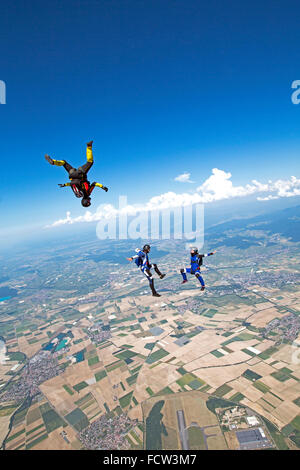 This freefly skydiving team is training together in the sky. Thereby they are having fun and fly with speed around each other. Stock Photo