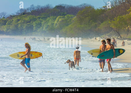 Surfers on this popular southern surf beach near Mal Pais on the Nicoya Peninsula; Santa Teresa, Puntarenas, Costa Rica Stock Photo