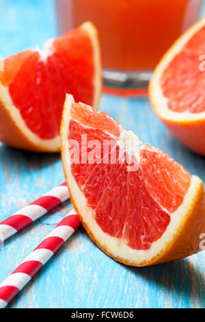 sliced grapefruit, grapefruit juice on blue wooden background Stock Photo