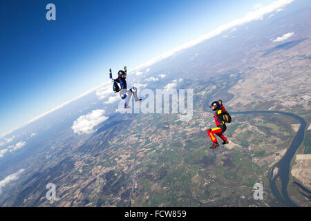 This skydive freefly team is training the sit-fly formation together. With over 125 mph they fly in the blue sky and having fun. Stock Photo