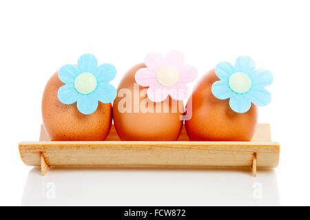 three eggs on wooden plate over white background Stock Photo