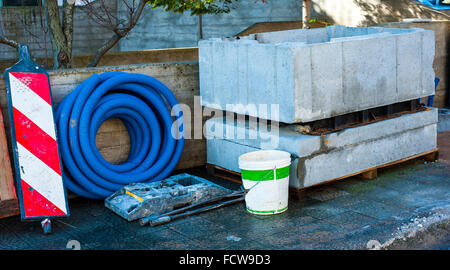 Pit precast concrete block and roll corrugated conduit deposited on a sidewalk Stock Photo