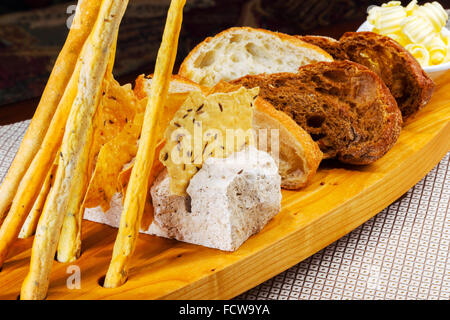 Various kinds of fresh baked bread loaves in wooden tray Stock Photo
