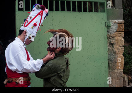 A white Danzarin (another character carnival Vijanera) helps another participant to tie the mask. Stock Photo