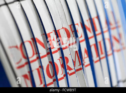 'CONFIDENTIAL INFORMATION' paper through a shredder. Stock Photo