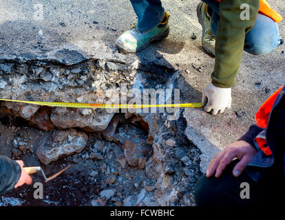 workers check a tape measure the width of excavation at a construction site Stock Photo