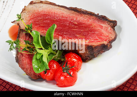 Medium Grilled steaks and savory tomato sauce Stock Photo