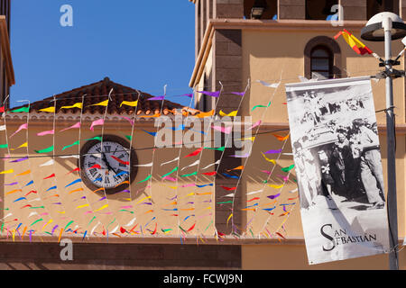 Flags and bunting decorating the front of the church for the fiesta of San Sebastian, La Caleta, Costa Adeje, Tenerife, Canary I Stock Photo