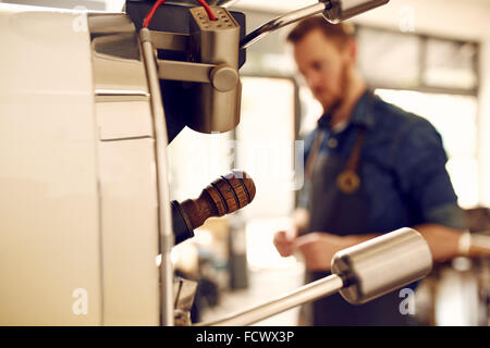 Coffee bean roasting machine with man in the background Stock Photo