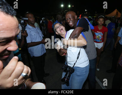 Port of Spain, Trinidad. 24th January, 2016. Keith Christopher Rowley (C), Prime Minister of Trinidad & Tobago, hugs Maria Nunes at the semi-finals of Panorama in the Queen's Park Savannah during Carnival in Port of Spain, Trinidad on Sunday January 24, 2016. (Photo by Sean Drakes/Latin Content/Getty Images) Stock Photo