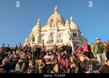 Tourists, crowd sitting in front of Sacred Heart Church or Sacre Coeur in Montmartre, Paris, France. Stock Photo