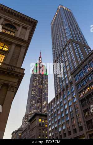 Empire State Building at twilight illuminated with red, green and white Christmas lights. 5th Avenue, Manhattan, New York City