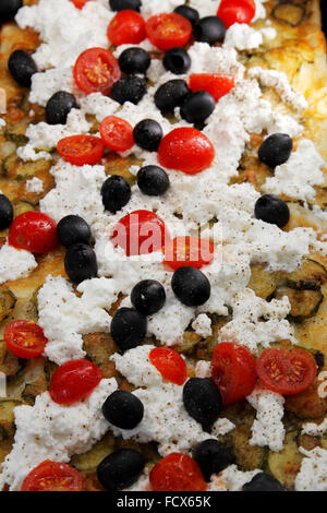 pizza with tomatoes, olives, zucchinis and sheep cheese in a Pizzeria in Rome, Italy Stock Photo