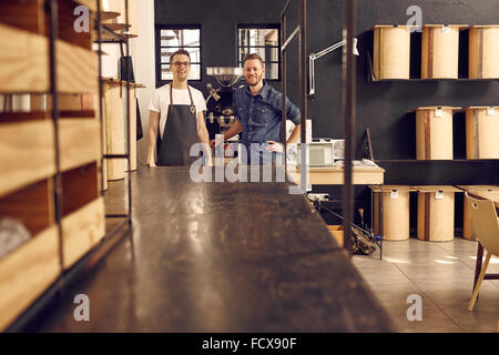 Two hipster men smiling in a modern coffee roastery Stock Photo
