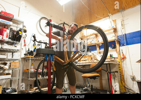 Skilled craftsmen create beautiful wooden frames from raw wood to create high end, expensive bicycles. Stock Photo