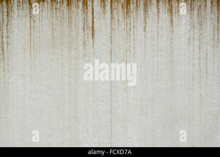 Background of dirty brown streaks dripping vertically on pale gray wall surface. Stock Photo