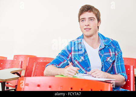 Motivated student taking notes in class in high school Stock Photo