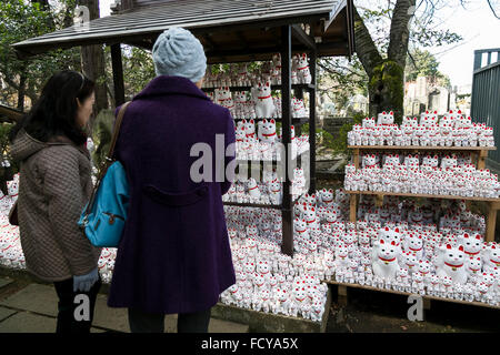 Tokyo, Japan. 26th January, 2016. Visitors look at the Maneki-Neko figurines on display at Goutoku Temple on January 26, 2016 in Tokyo, Japan. The temple and the surrounding area is well known for its massive collection of Maneki-Neko, literally beckoning cats. The cats are a common Japanese charm thought to bring good luck to the owner. They are often displayed at the entrance to shops and restaurants but Goutoku Temple goes one further and displays over 1000 cats throughout its ground. Credit:  Rodrigo Reyes Marin/AFLO/Alamy Live News Stock Photo