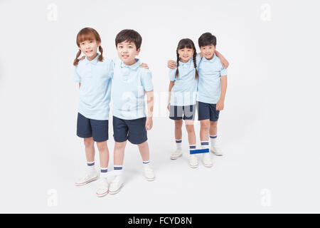 Four elementary school students in sportswear doing three legged race Stock Photo