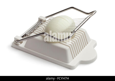 Boiled egg in an egg slicer on white background Stock Photo