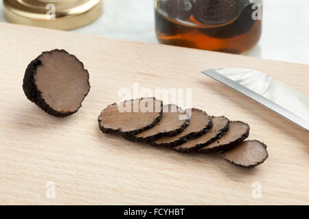 Preserved summer truffle from a pot cut into slices on a cutting board Stock Photo