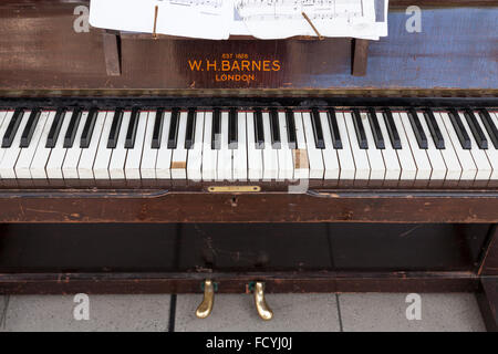 Keyboard with damaged keys of an old upright piano by W H Barnes, UK Stock Photo