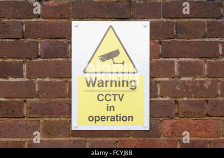 Sign warning of CCTV in operation on a brick wall Stock Photo