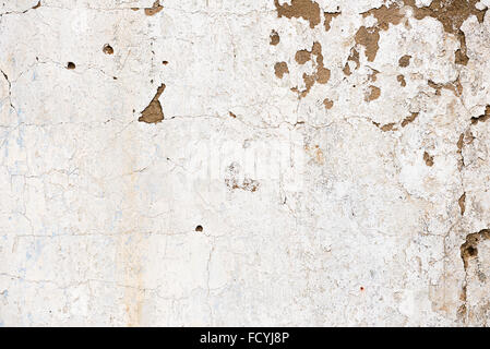 Old, grungy white background of natural plaster wall surface for texture or backgrounds. White hause wall with cracks. Stock Photo