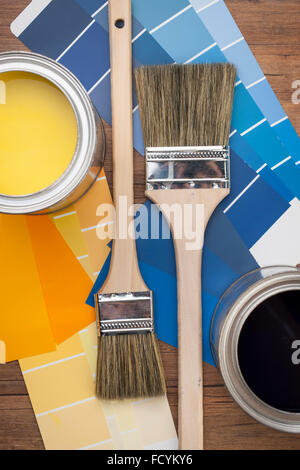 High angle of paint pots and color schemes with brushes in yellow and blue shades Stock Photo