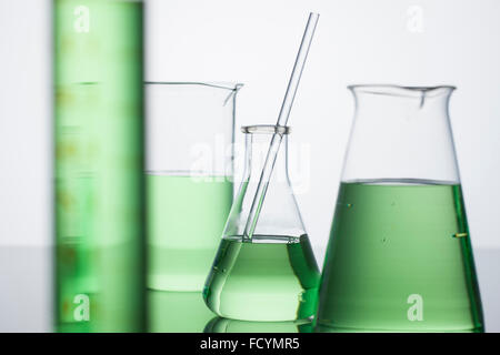 Variety of laboratory glass equipment with green liquid filled Stock Photo