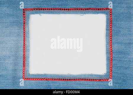 The frame is made from denim with red rhinestones  on a white background. With space for text Stock Photo