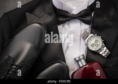 Man's tuxedo with black shoes, cologne, and a watch Stock Photo
